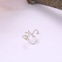 Silver wavy tragus cuff displayed on white background, showcasing delicate curved design with ball accents