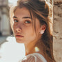 White flower clip-on earrings side profile view worn by woman with brown hair