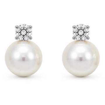 A pair of silver-toned drop earrings featuring a large white pearl and a round clear gemstone, shown on a white background.