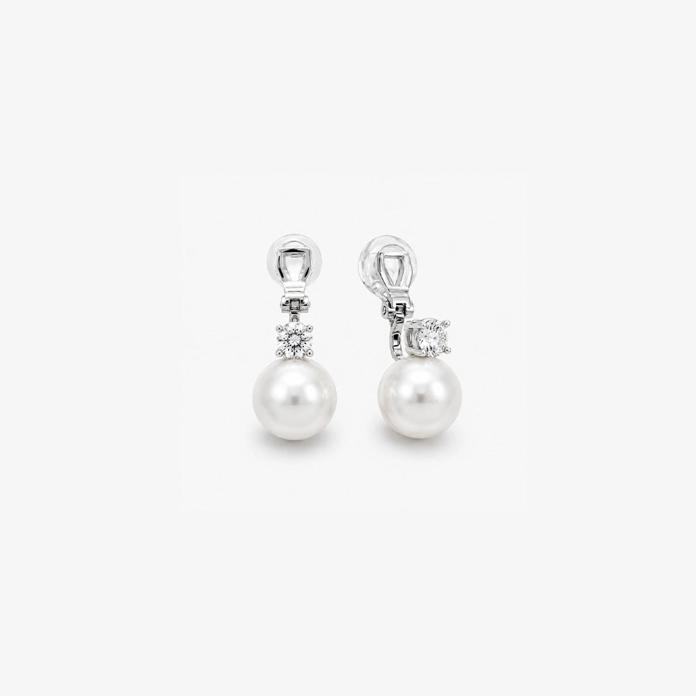 Pair of White Pearl Drop Clip-On Earrings in Silver Setting displayed, capturing the elegant design and color contrast.