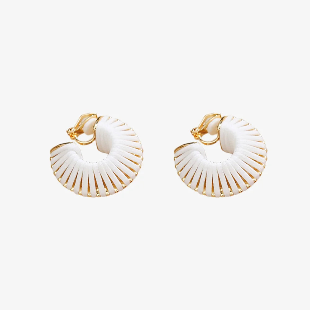 Pair of white leather wrapped clip-on hoop earrings on fabric