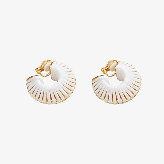 Pair of white leather wrapped clip-on hoop earrings on fabric