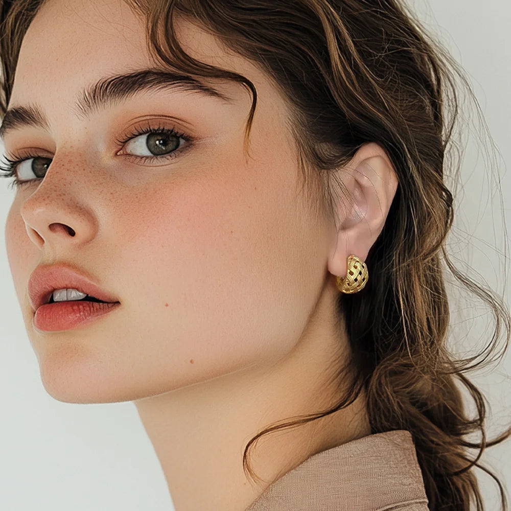 Gold woven crescent clip-on hoop earrings on model, side profile view showing textured finish and elegant design