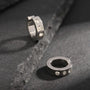 Silver zirconia bold clip on hoop earrings displayed on dark stone surface, showing sparkling crystal details and polished finish