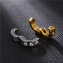 Silver and gold zirconia bold clip on hoop earrings displayed on dark textured surface