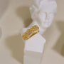 Manchette d'oreille en or à chevrons pavés, présentée sur un buste blanc, mettant en valeur son design d'inspiration Art déco.