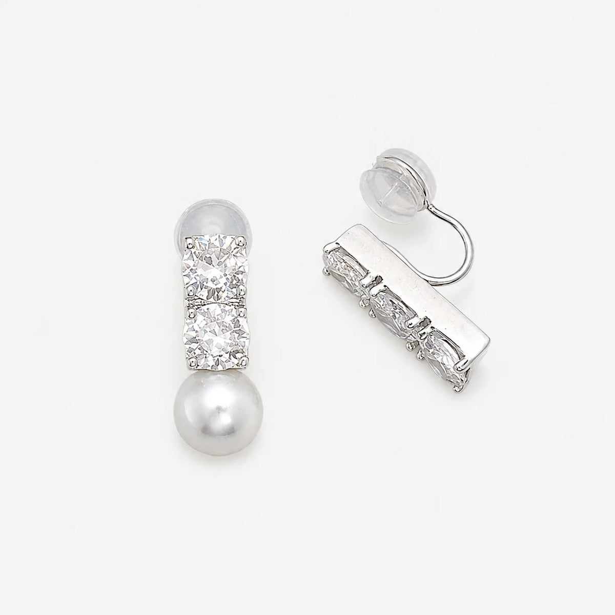Asymmetrical CZ and pearl clip-on earrings showing the open C-Type clip and clear resin pad
