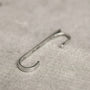 Side angle view of the Axis sterling silver ear cuff, showing its hook detail and brushed metal texture.