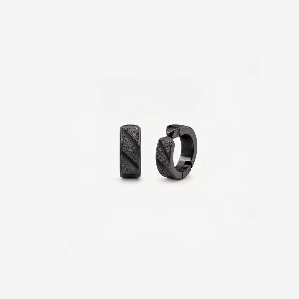 Pair of black faceted clip on huggie hoop earrings shown from the front