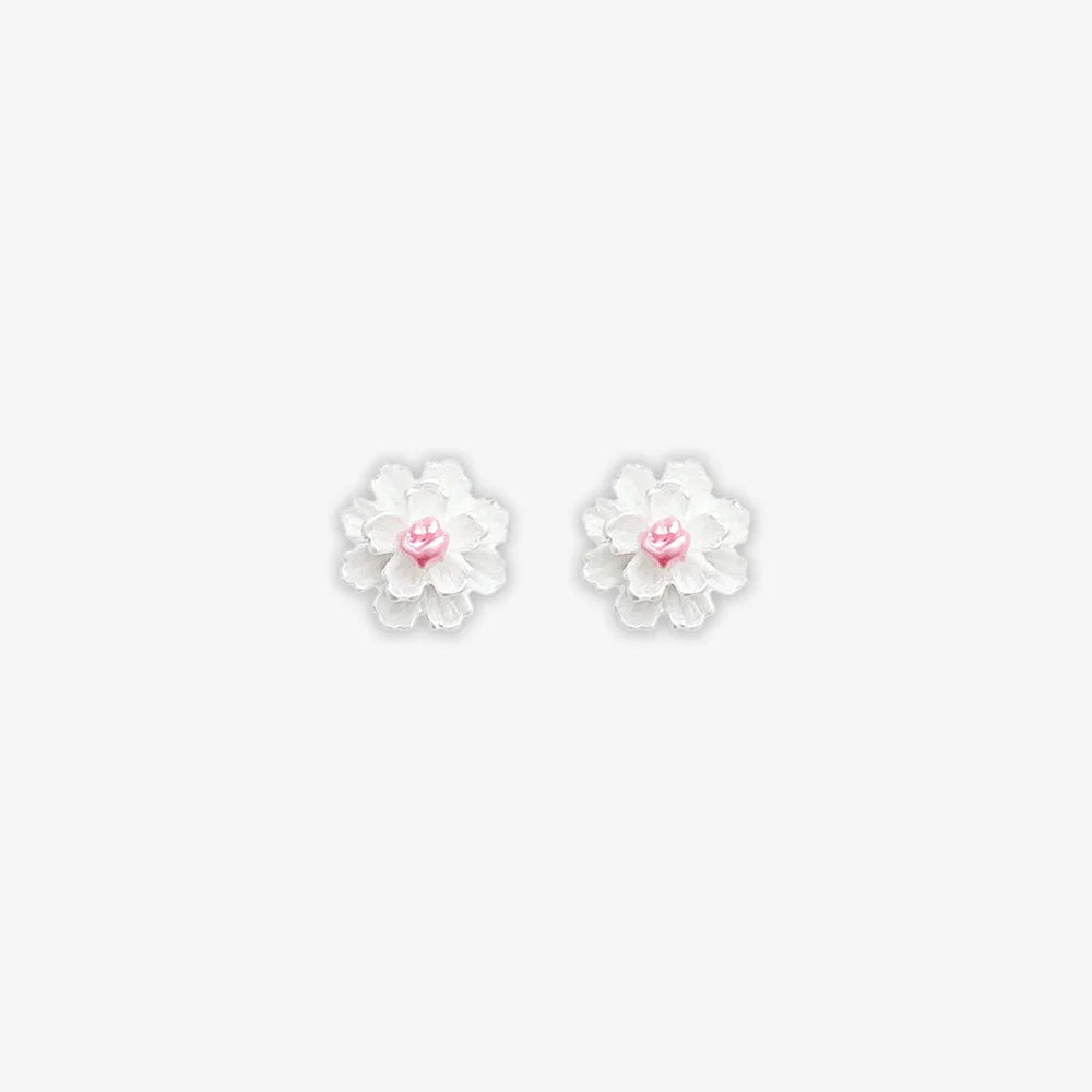 Isolated close-up of two white cluster petal magnetic stud earrings with vibrant pink centers on a clean white background.