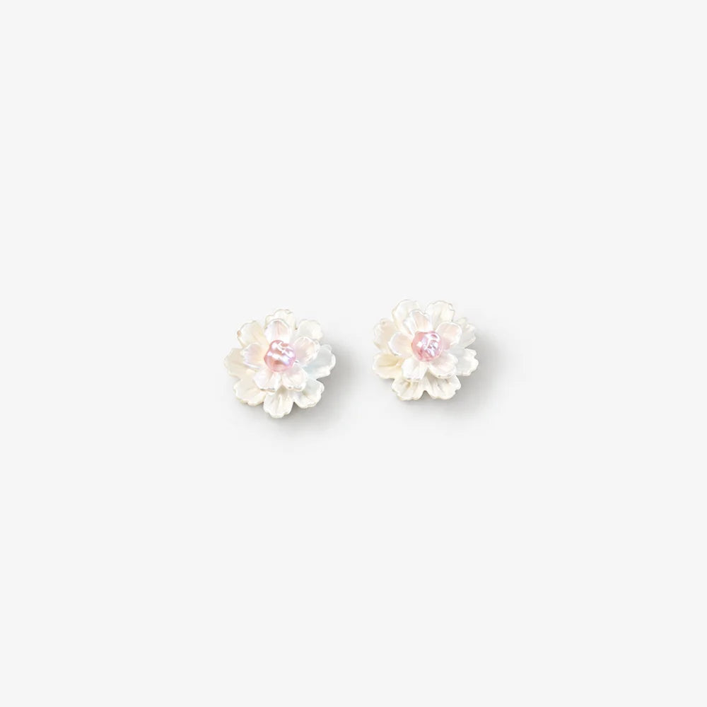A pair of small flower-shaped stud earrings with iridescent white petals and soft pink centers, shown on a plain light gray background.