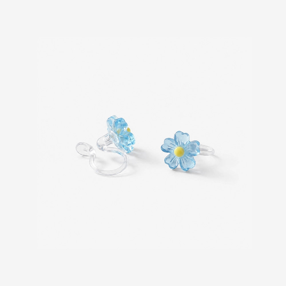 Pair of sky blue daisy candy color earrings with a translucent jelly finish on a soft textured background.