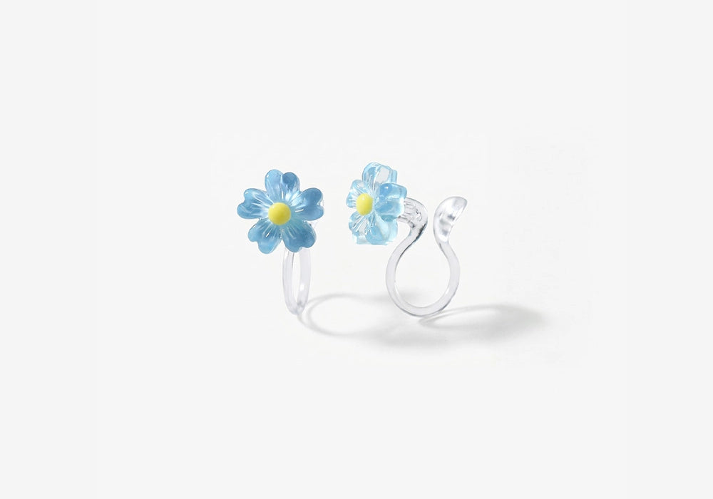 Close-up of the translucent blue resin petals and the clear stud clip-on mechanism for non-pierced ears.