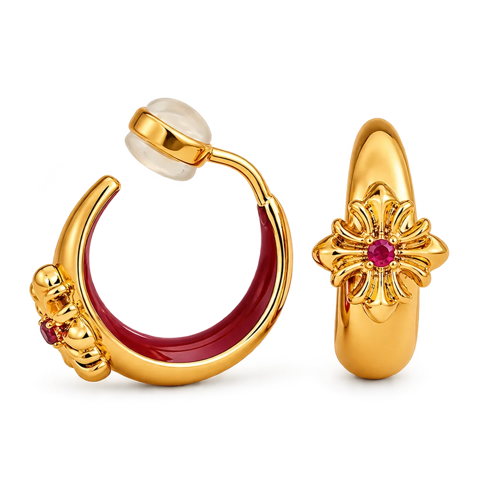 A pair of gold hoop earrings with red enamel inlays, floral gold details, and small red gemstones, shown on a clean white background.