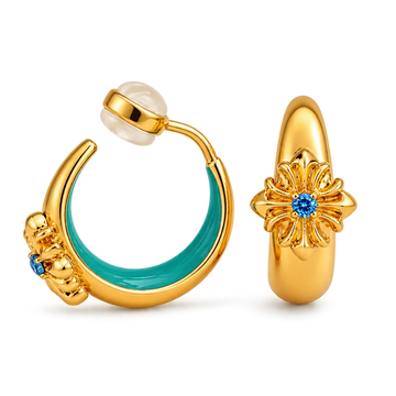 A pair of gold hoop earrings shown on a clean white background. One earring is open and displays a curved gold body with a turquoise enamel inlay and a small blue gemstone.