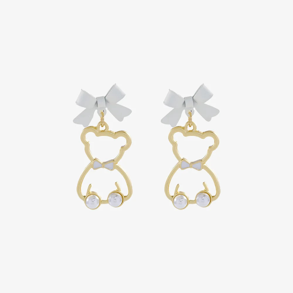Gold bow-tied bear pearl clip-on earrings front view with white bows and pearl details on white background