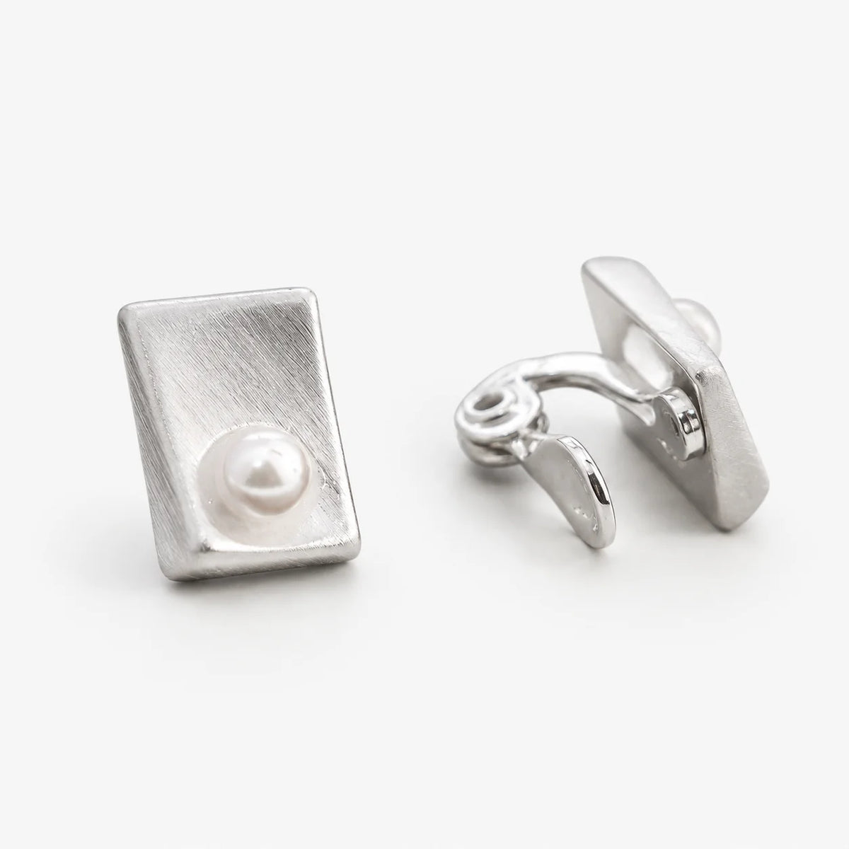 Brushed rectangle pearl clip-on earrings showing the adjustable hinged clip from the back