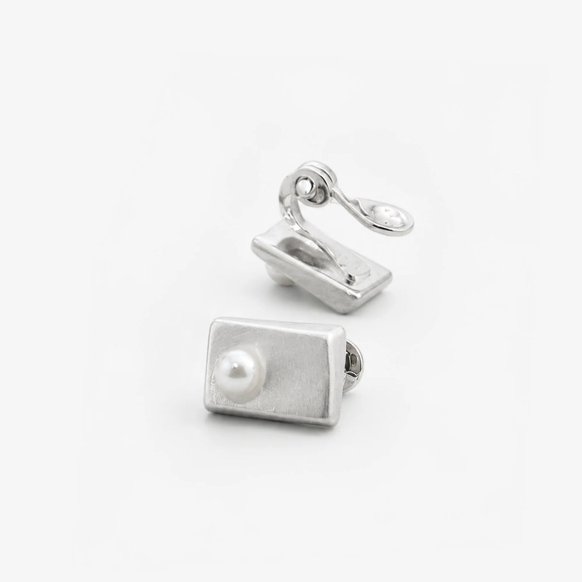Side and front views of brushed silver-tone rectangle pearl clip-on studs