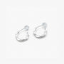 Close-up of brushed silver sculptural clip-on earrings on a marble surface showing the comfort c-type clip on.