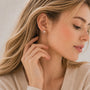 Side view of a woman wearing gold celestial pearl crescent clip on earrings for a minimalist look.