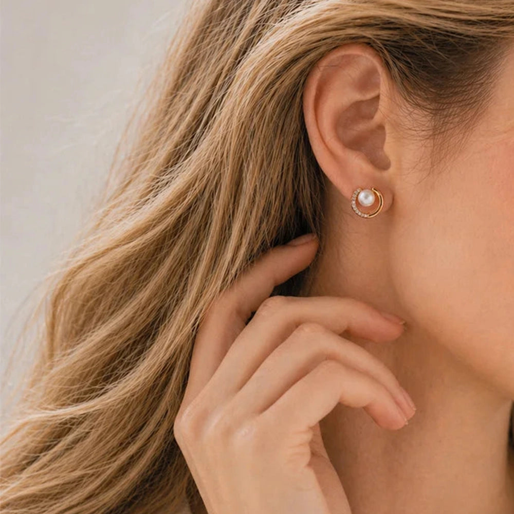 Side view of a woman wearing gold celestial pearl crescent clip on earrings for a minimalist look.