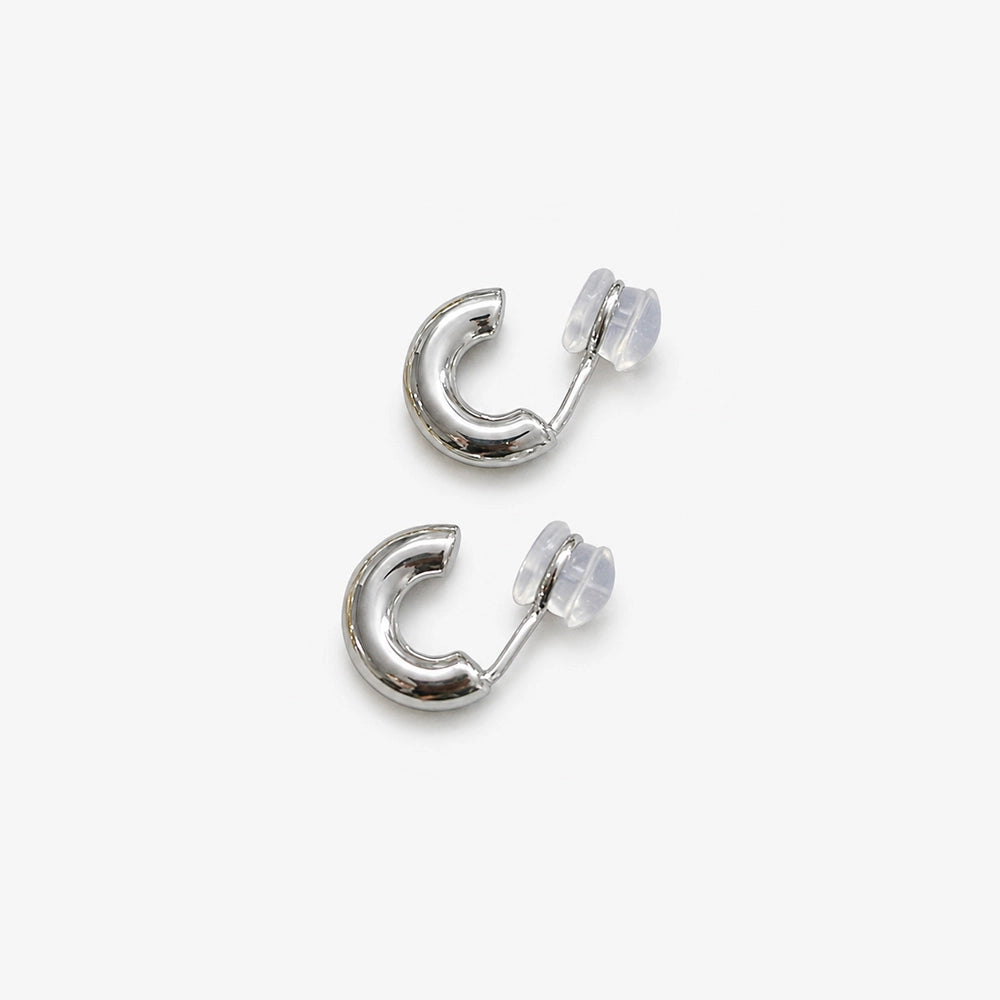 Chunky silver clip on huggie hoop earrings showing the cushioned clip on closure