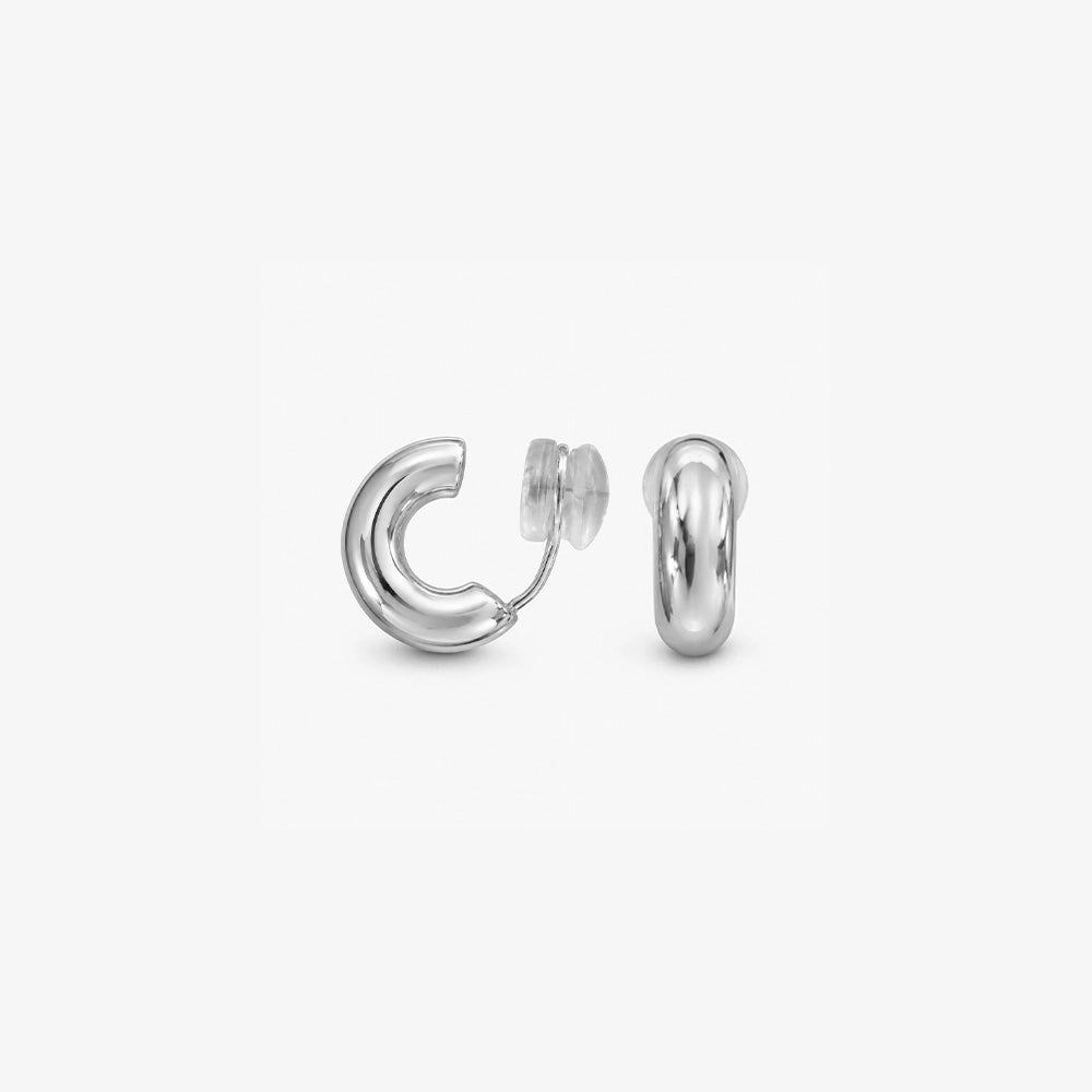 Pair of chunky silver clip on huggie hoop earrings shown from the front