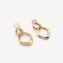 A close-up view highlighting the intricate pavé zircon details on the connector link of the gold geometric clip-on earrings.