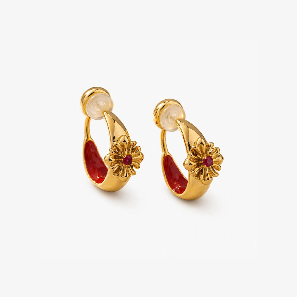Close-up of crimson enamel and gold bohemian ear clips on a natural stone surface highlighting the cross design and CZ sparkle.