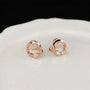 Pair of dainty rose gold twisted circle earrings with a small solitaire stone, perfect for luxury everyday wear.