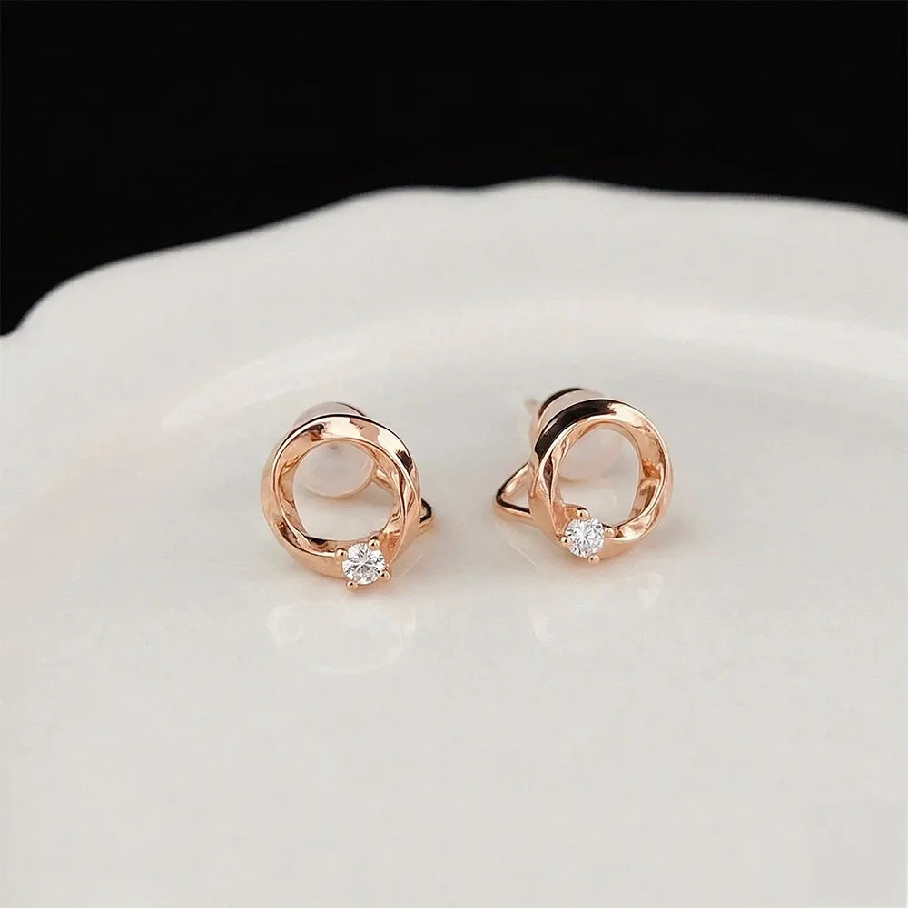 Pair of dainty rose gold twisted circle earrings with a small solitaire stone, perfect for luxury everyday wear.