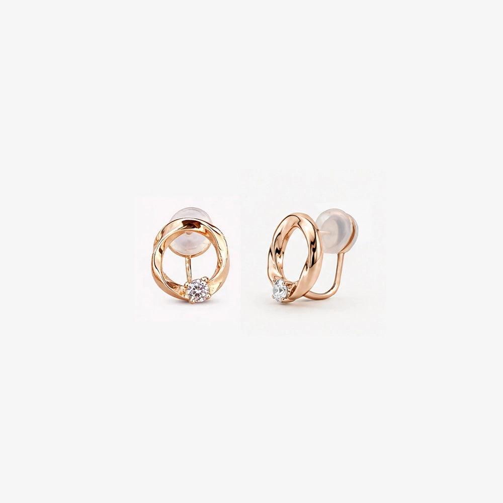 Pair of 18K rose gold twisted circle stud earrings with a central round solitaire stone on a clean white background.
