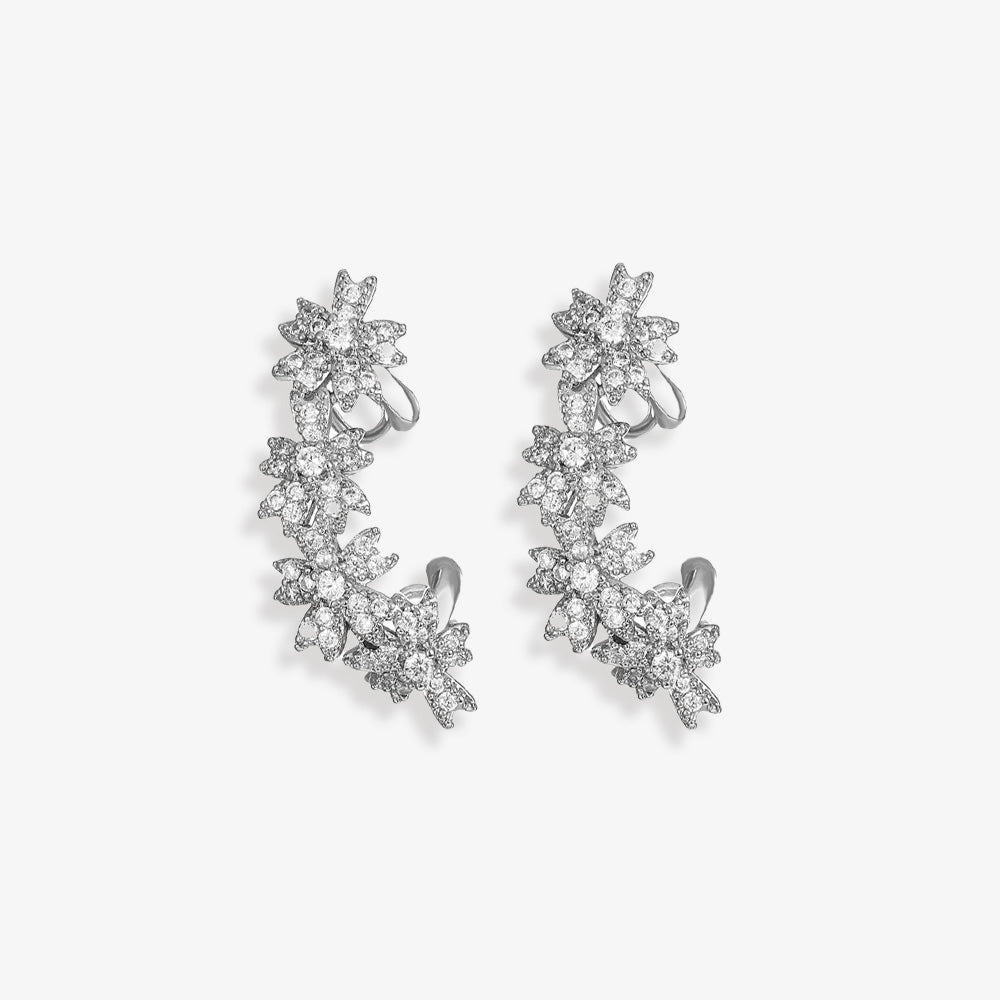 A pair of white gold Blossom Flower Crystal Helix Ear Cuffs, showcasing the intricate petal design and zircon gemstones that perfect for wedding elegance, offer a radiant sparkle for any bride.