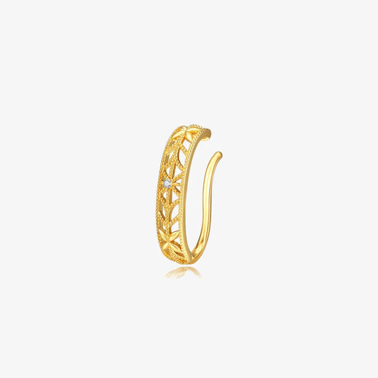 Vintage-style gold ear cuff with a floral filigree pattern and a small crystal accent, shown on a white background.