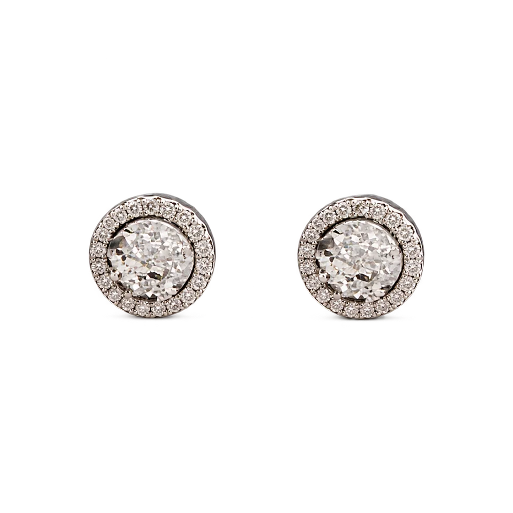 A pair of round stud earrings featuring textured white zircons centers surrounded by a halo of small clear stones in a silver-toned setting, shown on a plain white background.