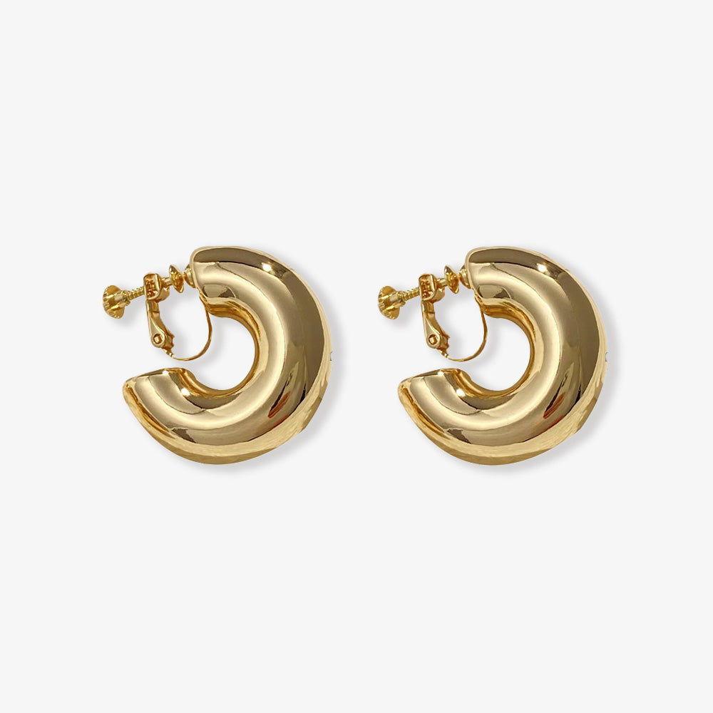 Gold-toned bold hoop clip-on earrings, modern style with a screw-back closure made from copper alloy. Ideal statement huggie earrings for those seeking a classic yet striking accessory.