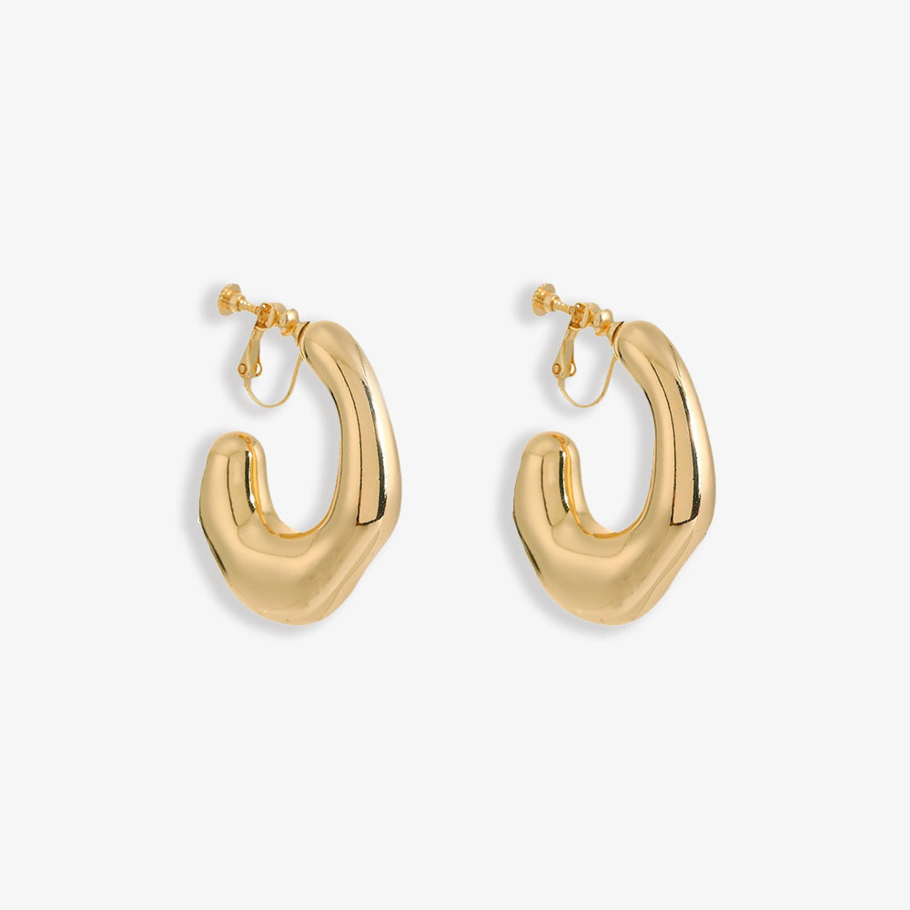 Chunky Curved Hoop Clip On Earrings in polished gold alloy make a bold statement. Their modern design curves smoothly, reflecting light for an impactful shine. The secure screw-back clip-on closure ensures comfort for non-pierced ears.