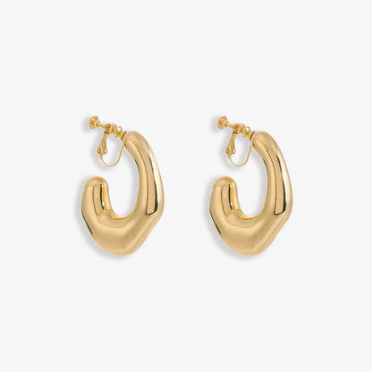 Chunky Curved Hoop Clip On Earrings in polished gold alloy make a bold statement. Their modern design curves smoothly, reflecting light for an impactful shine. The secure screw-back clip-on closure ensures comfort for non-pierced ears.