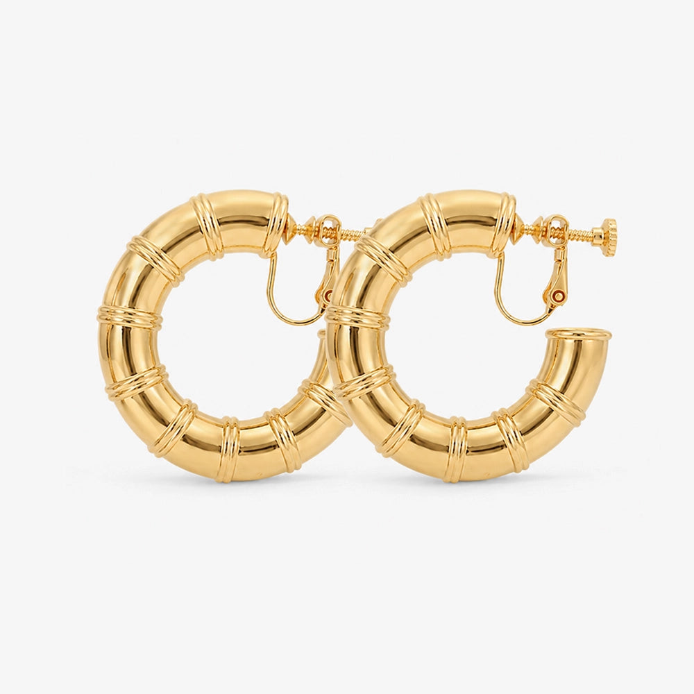 A pair of gold bamboo hoop clip-on screw back earrings on a white background
