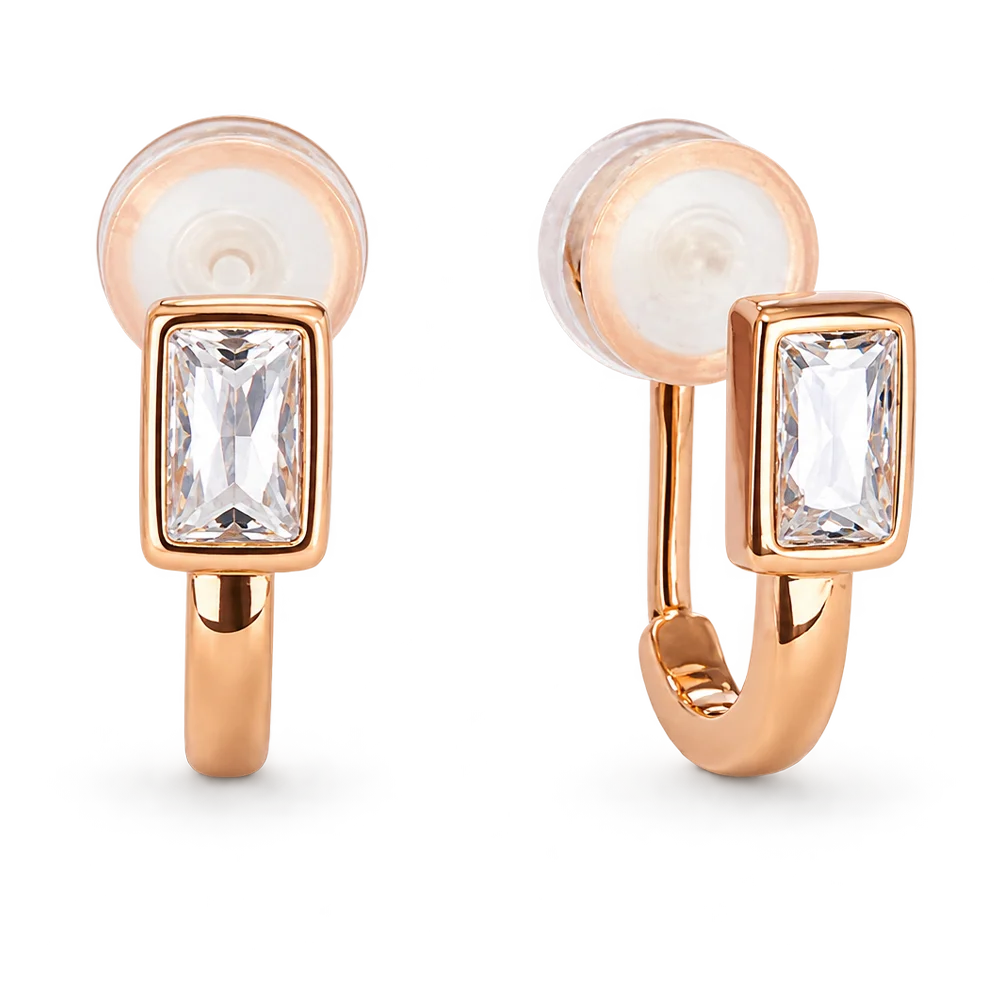 A pair of rose gold huggie hoop earrings with rectangular bezel-set clear crystals and silicon pad clip backings, shown on a clean white background.