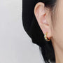 Gold Chain Zirconia Clip-On Hoop Earrings worn on a model's ear, close-up
