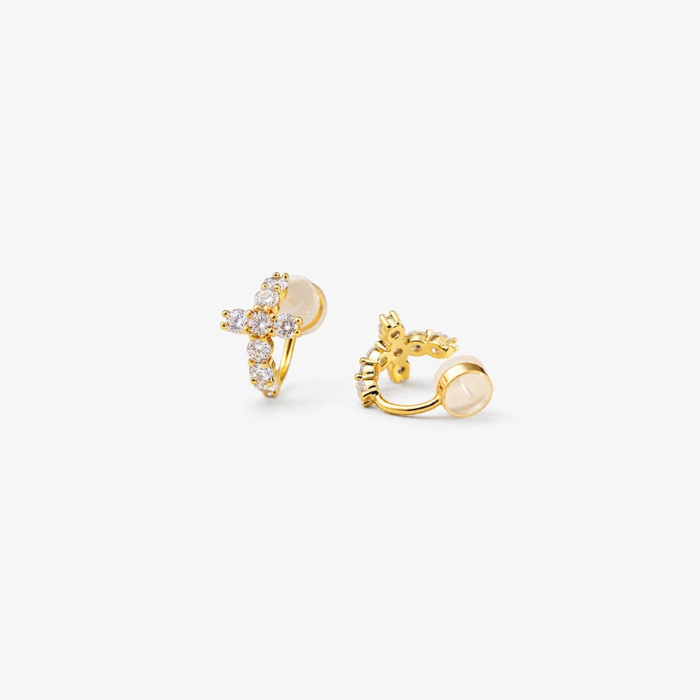 Angled view of the cushioned clip on closure on a gold cross huggie earring