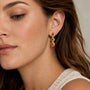 Woman wearing a gold multi gemstone drop clip on earring on a non pierced ear