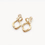 The back view of the gold geometric drop earrings, clearly showing the comfortable and adjustable clip-on mechanism with its silicone pad.