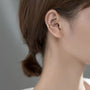 Gold Helix cross ear cuff in sterling silver worn on ear, side profile view 
