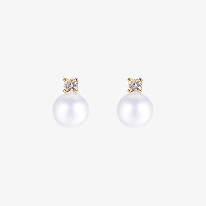 Pair of White Pearl Drop Clip-On Earrings in Gold Setting displayed on a soft beige surface, capturing the elegant design and color contrast.