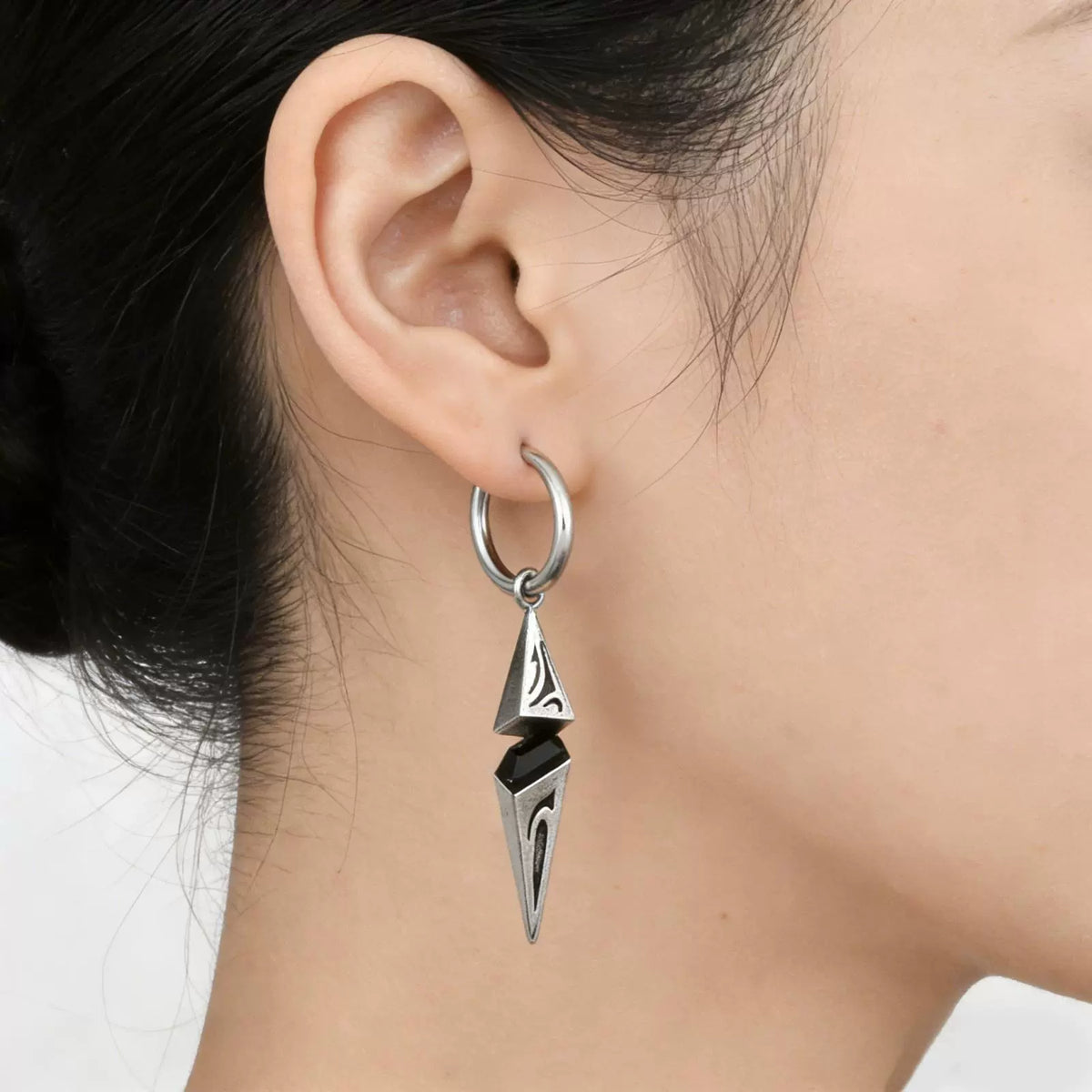 Gothic spike dangle clip-on earring worn on a non-pierced ear, looking like a pierced hoop