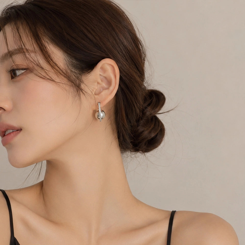 Woman wearing a grey pearl clip on hoop earring on a non pierced ear