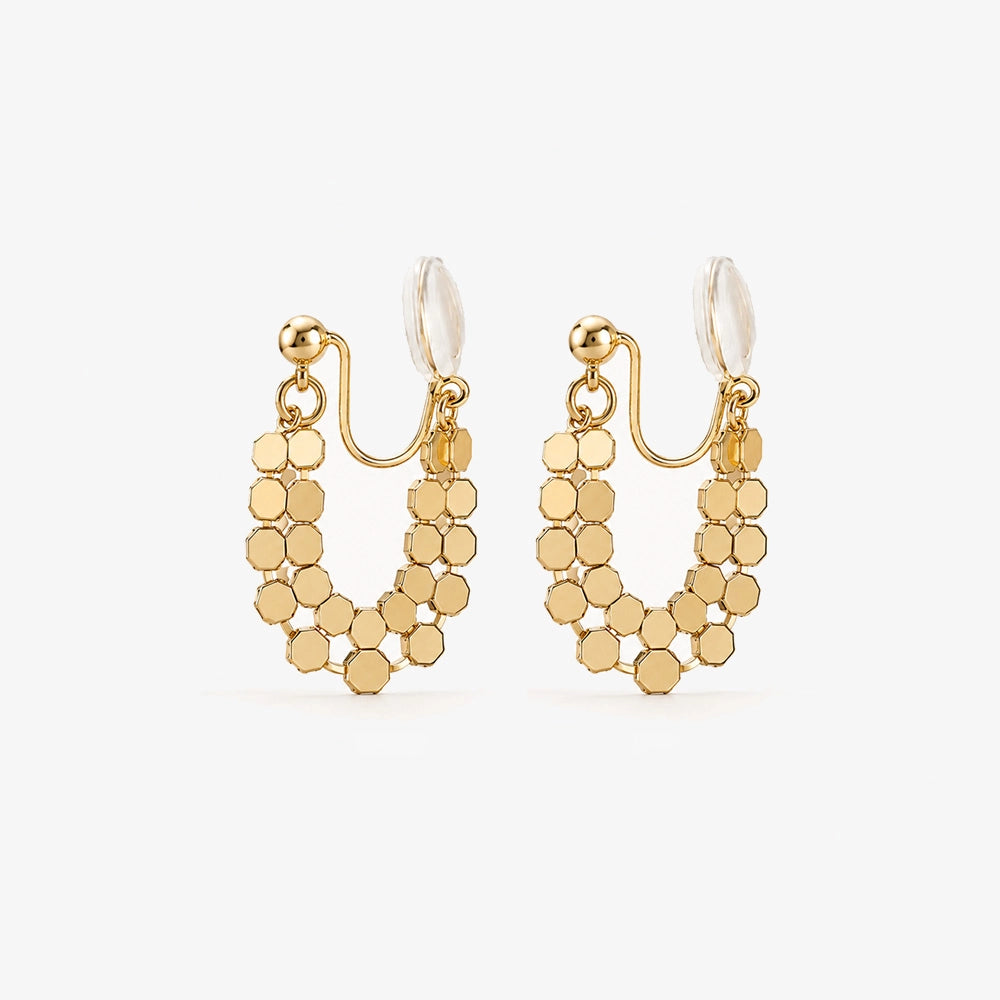 A pair of gold honeycomb mesh clip-on hoop earrings in a U-shape design, shown on a clean white background.