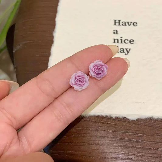 Showcase lavender rose magnetic clip‐on stud earring on hand.